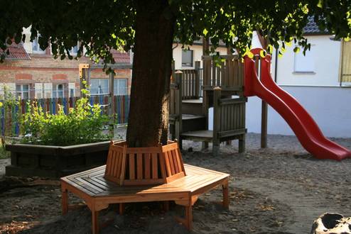 Der Hof mit Bank am Baum und Rutsche im Kindergarten Hohensachsen