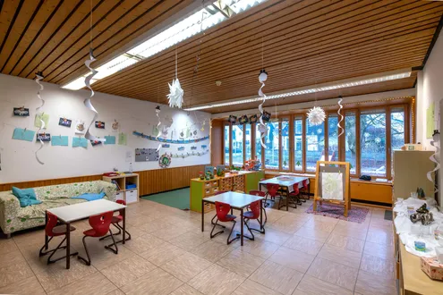 Zimmer mit Tischen, Sofa und Leinwand