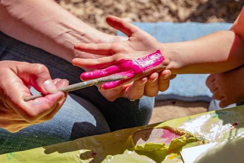 Kinderhand wird bunt bemalt