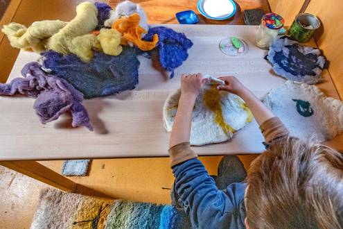 Kind filzt mit buntem Filz