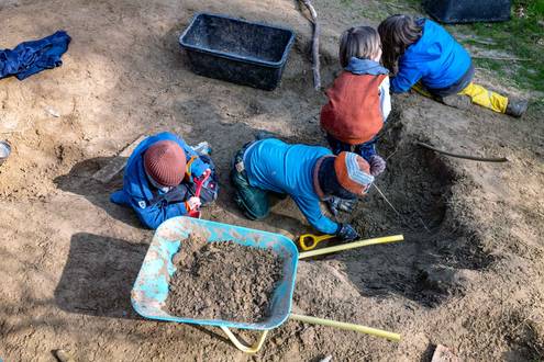 Kinder mit Schaufeln und Schubkarre im Waldkindergarten Hemsbach